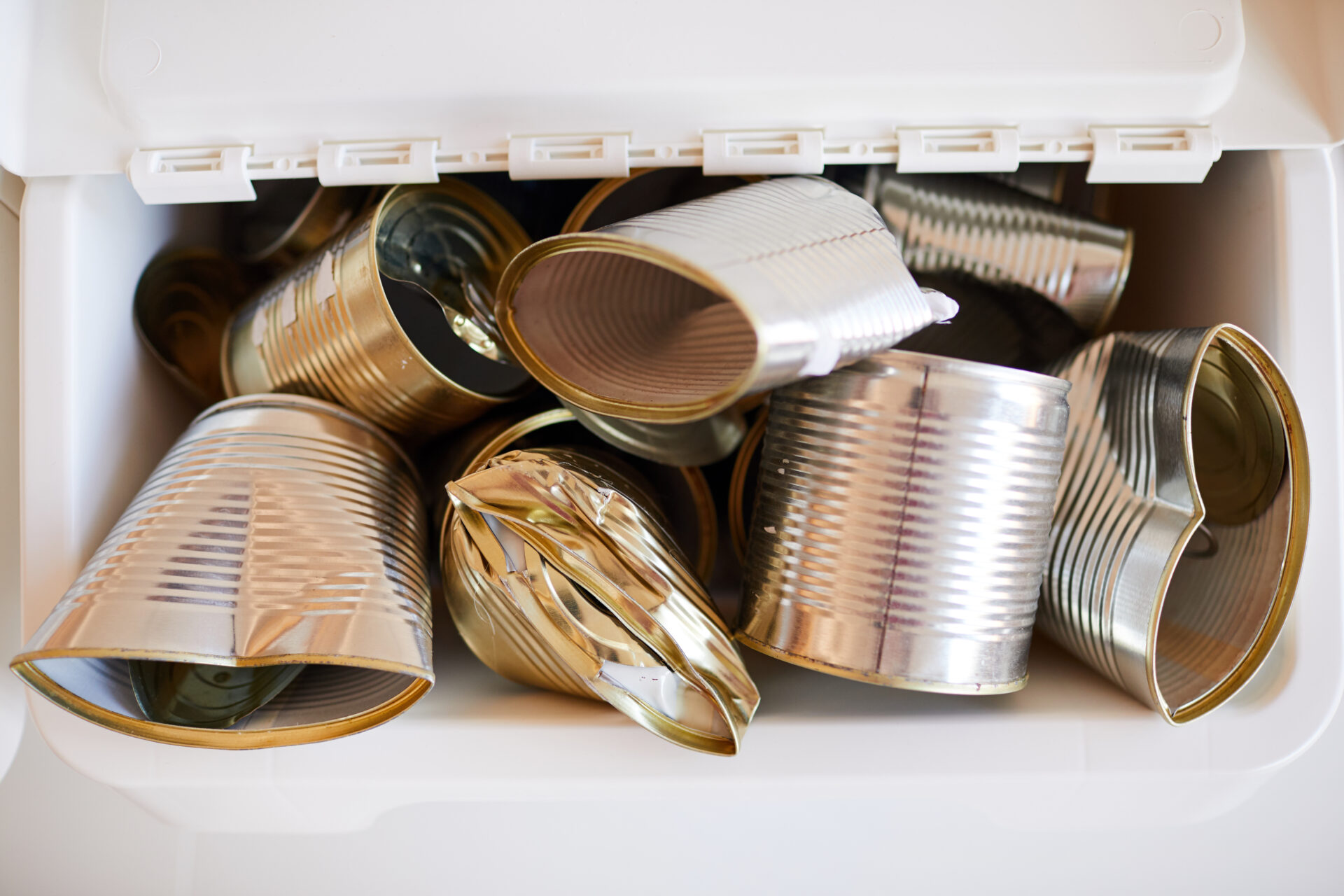 Close up background image of discarded metal cans stored in plastic bin and ready for recycling, waste sorting scrap metal