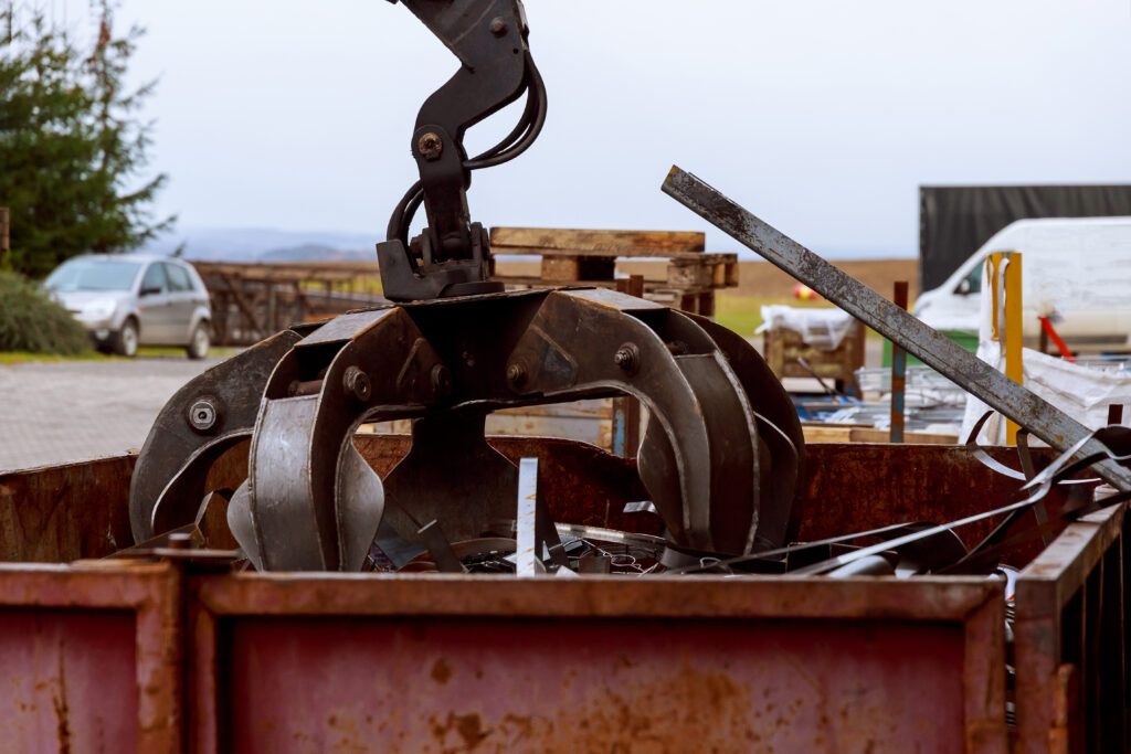 Loading scrap metal into a truck. Crane grabber loading metal rusty scrap in the dock construction scrap metal