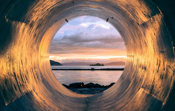 Metal tube reflecting the sunset at the beach