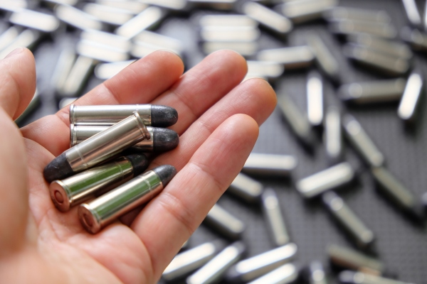man holding recycled brass shell casings